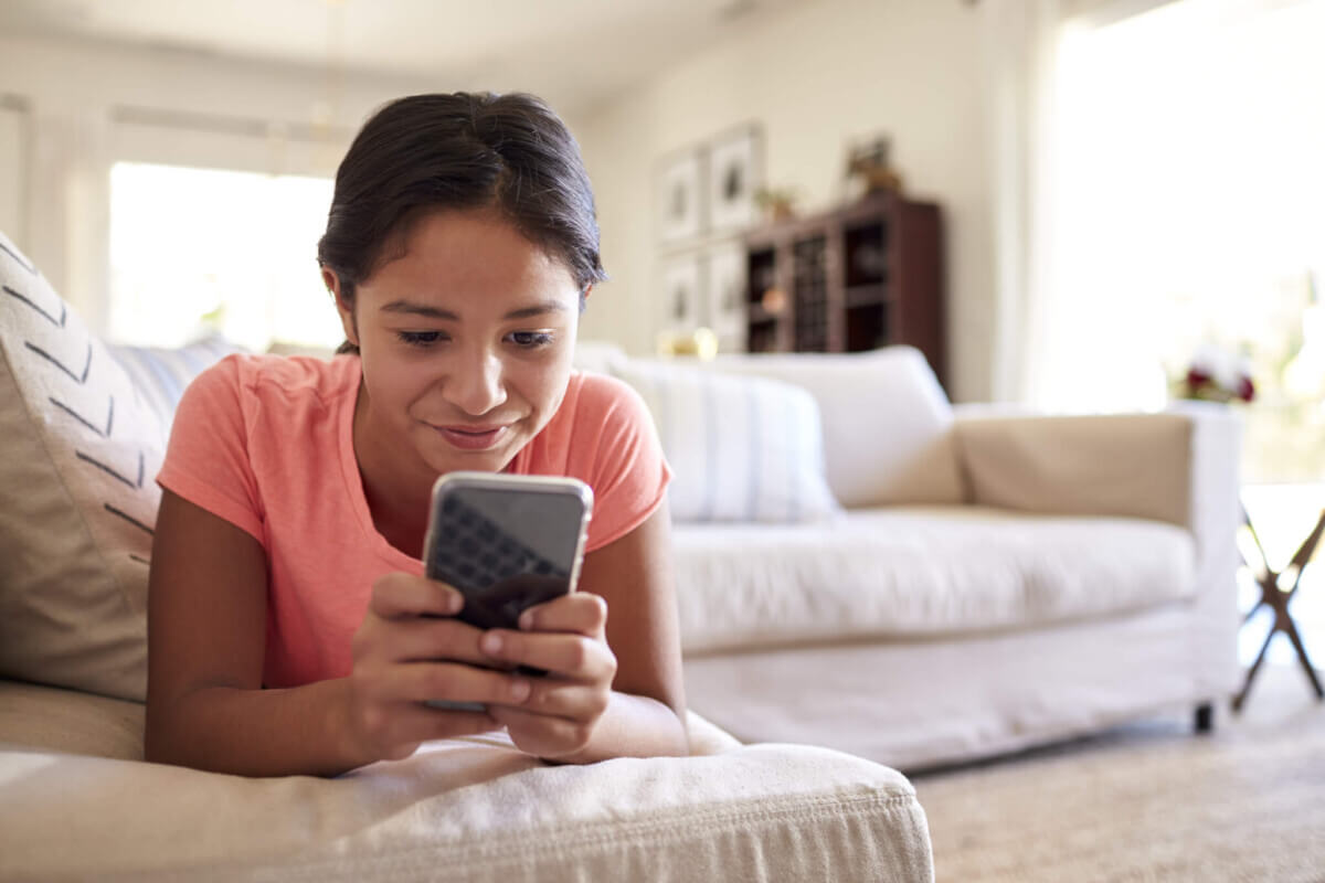 Screen time: Teenage girl looks at social media on smartphone